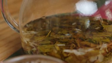 Bu video huzurlu bir çay içme deneyimi sunuyor. Canlı yeşil bir çaydanlık ile, bir fincana dönüşüyor, sakinleştirici ayini vurguluyor. Medya