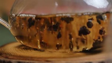 Bu video, kırsal bir masada dumanı tüten bir fincanla sakin bir çay hazırlama sahnesi içeriyor. İçi demlenmiş çay dolu cam çaydanlık rahatlamaya davetiye çıkarır. Medya