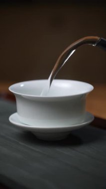Huzurlu ve huzurlu bir an, Çin çay takımlarıyla çay doldurma sanatını yansıtıyor. Medya