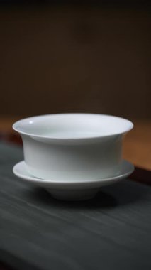 Minimalist beyaz porselen kaseler, altındaki ahşap yüzeyde zarif bir şekilde sergileniyor. Medya