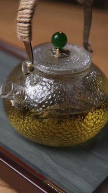 Nefis kokulu bitki çaydanlığıyla dolu güzel bir cam çaydanlık. Karmaşık bir tasarım ve canlı renkler sergiliyor. Medya