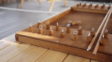 Çok güzel hazırlanmış ahşap bir oyun şu anda klasik bir ahşap masada dinleniyor ve büyüleyici bir iç mekan ortamı yaratıyor. Yaratıcı