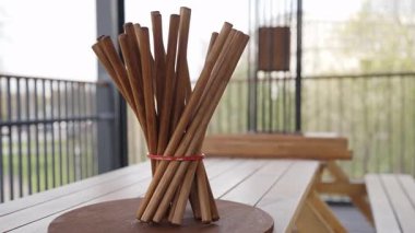 Modern bir sanatsal sergi, tarçın çubuklarını, güzelliklerini vurgulamak için minimalist bir tarzda sergiliyor. Yaratıcı