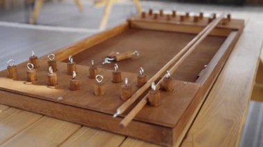 Kırsal bir masada el yapımı ahşap bir masa oyunu, oyuncuları heyecan verici bir oyun gecesine davet ederek, toplantılar için samimi bir ortam yaratır. Yaratıcı