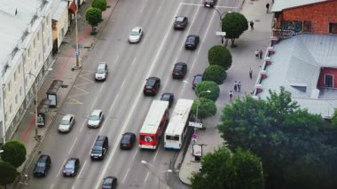 Çarpıcı bir hava manzarası yoğun trafik ve yemyeşil ağaçlarla dolu hareketli bir şehir caddesini gözler önüne seriyor. Medya