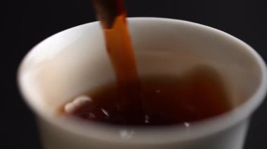 Zengin, koyu bir içeceğin bardağa doldurulup canlı renkleri ve dokuları sergilendiği yakın plan bir fotoğraf. Medya