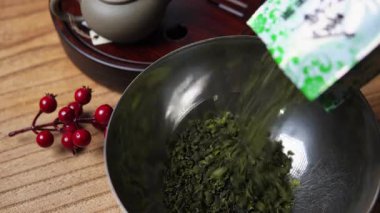 Huzurlu ve huzurlu bir sahne yeşil çay hazırlama sanatını sergiliyor, doğal sakinliği vurguluyor. Medya