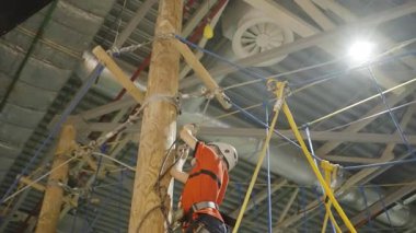 Bir dağcı, yerden yükseklerde, atletik beceri ve odaklanma gösteren zorlu bir halat kursuna katılır. Yaratıcı