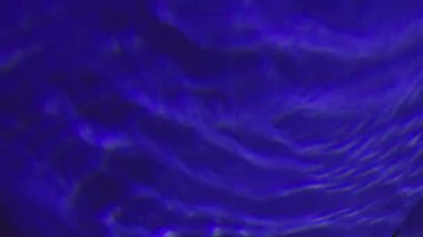Pürüzsüz mavi sıvı hipnotik eşmerkezli daireler oluşturur.