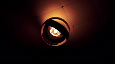 Modern tavan lambası karanlık bir odada nazikçe sallanıyor. Tasarım