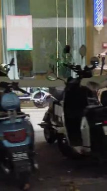 Guangzhou, Çin - 12 Temmuz 2024: Kalabalık bir şehir ortamında canlı cadde boyunca düzgün park edilmiş çok sayıda motosikletin büyüleyici bir görüntüsü. Medya