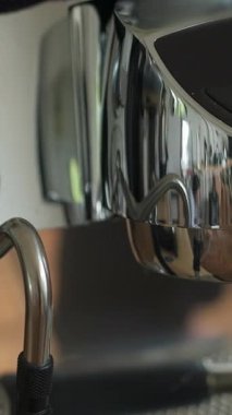 Parlak bir espresso makinesi krom kaplama ve demleme bileşenlerini sergiliyor. Kahve meraklıları için mükemmel. Medya