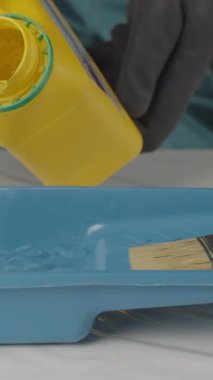 Bu sanatsal derste bir kişi boya tepsisini su ve fırçayla hazırlıyor ve renkli bir resim seansı için zemin hazırlıyor. Yaratıcı