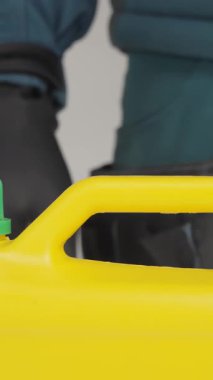 Bu videoda, bir adam yeşil kapaklı sarı bir konteynırla etkileşime geçiyor, içindekileri göstermek ve önemini vurgulamak için dikkatlice açıyor. Yaratıcı