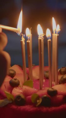 Mumlar güzel dekore edilmiş bir doğum günü pastasında taze, renkli meyvelerle parlarken neşeli anlar ortaya çıkar. Stock Görüntüsü