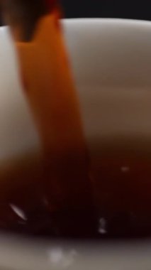 Zengin, koyu bir içeceğin bardağa doldurulup canlı renkleri ve dokuları sergilendiği yakın plan bir fotoğraf. Medya