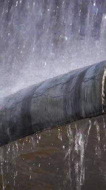 Sonbahar gününde çeşme su sıçratır. Görüntü. Su damlaları mermer kaideyi yıkıyor. Yakın plan, su köpüğü.