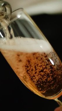 Gül şarabı bir garsonun elinde bardağa dökülür. Medya. Yakından şişenin boynu kaseye dökülüyor. Ağır çekim. Çerçevede yumuşak bulanıklık, canlı çekim. Şarap Degustation. Şaraphane konsepti