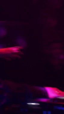 Akşam partisini elleriyle yöneten orijinal kostümlü DJ 'in arkasından bir manzara. Görüntü. Kız sunucunun rehberliğinde dans ediyor..