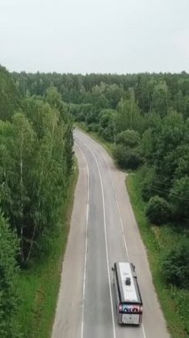Hava manzaralı yol güneşli bir yaz gününde uçsuz bucaksız ormanı geçiyor. Medya. Ulaşım ve doğa kavramı. Ulaşım ve doğa. Doğa ormanında yol. Üst görünüm karayolu hava görüntüsü hareketi