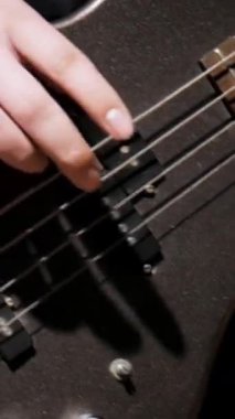 Adam ağır çekimde bas çalıyor. Evde elleri ve gitar çalan müzisyenlerin olduğu yakın çekim videoları var. Evde eğitim kavramı kal.