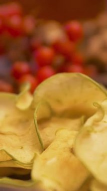 Masanın üzerine kurumuş elma dilimleri, kırmızı kızılcık, nane yaprağı ve ceviz koyun. Sağlıklı vejetaryen diyeti ve beslenme konsepti, masada yatan meyve, böğürtlen ve fındık..