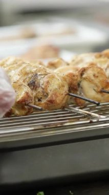Bir erkek eli kebabı döndürüyor. Medya. Eldivenli ellerle, ızgaradan yanmış eti koparıp daha fazla pişirmek ve doğru düzgün kızartmak için döner. Domuz eti, tavuk veya kuzu eti ızgarada kızartılıyor.