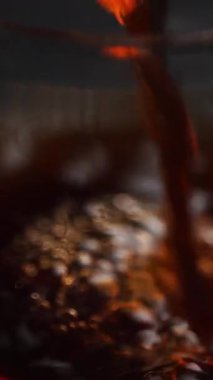 Koyu renkli bir sıvının zarif bir şekilde camdan bir çaydanlığa dökülmesi zengin renklerini gözler önüne seriyor. Medya