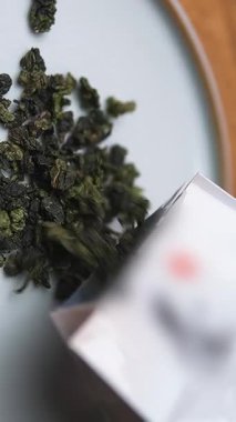 Dekoratif bir tabakta yeşil çay yaprakları sergilenen güzel bir estetik çay hazırlama sahnesi. Medya