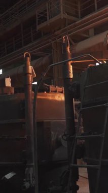 Fırınlardan çıkan yoğun alevlerle birlikte metal işleme süreçlerini gösteren endüstriyel bir sahne. Menkul Kıymetler