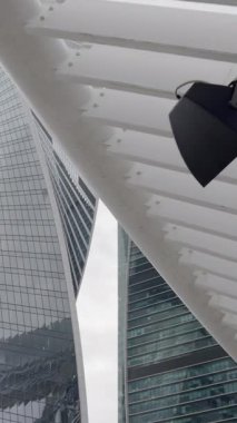 Bulutlu ve bulutlu bir gökyüzüne karşı inşa edilmiş çağdaş yapıların çarpıcı ve büyüleyici bir görüntüsü. Eylem