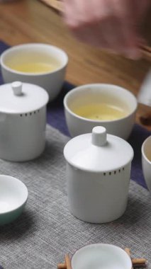 Zarif ve sakin bir çay seremonisi, nefis çaydanlıklar ve fincanlarla ahşap bir masada sergileniyor. Medya