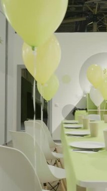 Parlak sarı balonlar, uzun bir şenlik masası ve neşeli bir atmosferi olan canlı ve canlı bir parti sahnesi. Yaratıcı