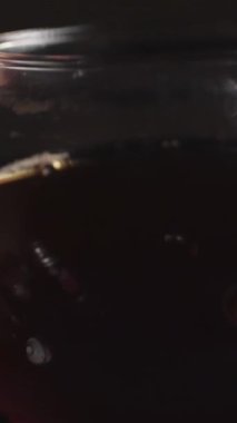 Nefis bir yakın plan çekimde bir el, cam çaydanlığı nazikçe tutuyor. İçi koyu demlenmiş çay dolu. Medya