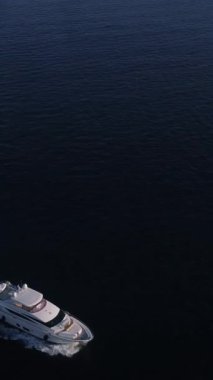 Beyaz lüks yat okyanusta yüzüyor. Kopyalama uzayı. Stok görüntüleri. Küçük bir açık deniz gemisi ilerlerken, deniz yüzeyinde köpük ve dalgalardan oluşan bir iz bırakarak insansız hava aracından ateş ediyorlar..