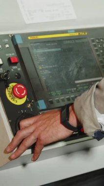 Bir operatör, modern bir imalat ortamında kullanılmak üzere tasarlanmış dijital bir kontrol paneliyle aktif olarak meşgul. Medya