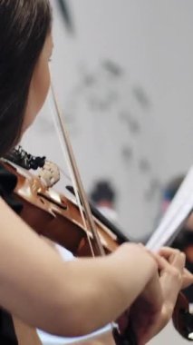Norveç, Stavanger, 08.01.2024: Güzel genç bayan müzisyen keman çalıyor. Medya. Kız müzik grubuyla müzik aleti çalma alıştırması yapıyor..