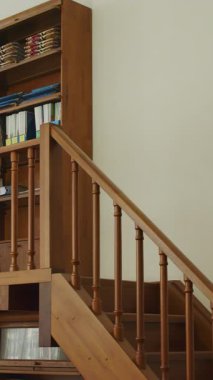 Sıcak ve davetkar bir kütüphanede, çalışkan bir kütüphaneci yüksek bir rafta kitapları düzenler ve düzenler. Medya