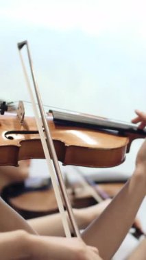 Norveç, Stavanger, 08.01.2024: keman çalan genç bayan müzisyen. Medya. Kız müzik grubuyla müzik aleti çalma alıştırması yapıyor..