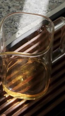 Ahşap bir tepside, üzerinde güzel fincanlar olan el yapımı cam bir çaydanlık çay kültürünün önemini vurgular. Medya