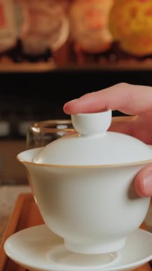 Bu video, ahşap bir masada, çay ve kahve doldurma, tefekkür etme anları ve samimi bir ortam içeren sakin bir içecek hazırlama ayinini vurguluyor. Medya