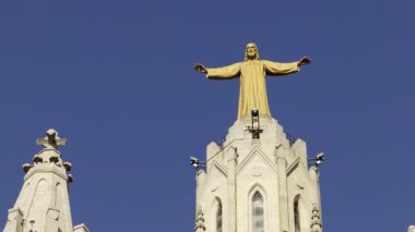 Barselona 'daki Tibidabo Dağı' nda tapınağın çatısında açık kolları olan İsa 'nın altın heykeli.