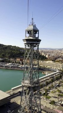Torre de Jaume 'un metal iskeleti teleferik kulesi, Barcelona Limanı ve Montjuic Hill' in panoramik manzarasını sunuyor.