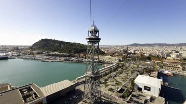 Torre de Jaume 'un metal iskeleti teleferik kulesi, Barcelona Limanı ve Montjuic Hill' in panoramik manzarasını sunuyor.