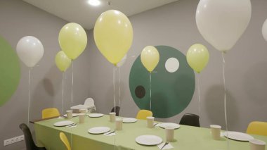 Neşeli ve canlı bir parti sahnesi canlı yeşil ve sarı balonlar sergiliyor güzel bir şekilde düzenlenmiş bir masanın yanında. Yaratıcı