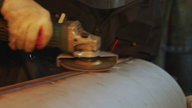 Yetenekli bir işçi metal bir boru üzerinde ustalıkla öğütücü kullanır, bu da zanaat ve sanayi uzmanlığını gösterir. Medya
