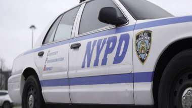 Beyaz NYPD polis arabası şehir caddesinde park halinde. Nezaket, profesyonellik ve saygı gösteriyor.