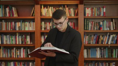 Düşünceli bir genç adam birçok sıra kitap rafının arasında ilginç bir kitap üzerinde çalışmaya dalmış. Medya