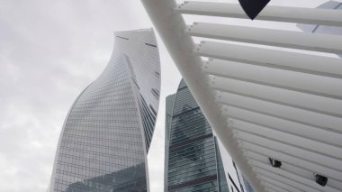 Bulutlu ve bulutlu bir gökyüzüne karşı inşa edilmiş çağdaş yapıların çarpıcı ve büyüleyici bir görüntüsü. Eylem