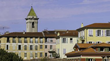 Geleneksel renkli binalar. Mavi gökyüzünün altında güzel bir kilise kulesi. Fransa 'da.